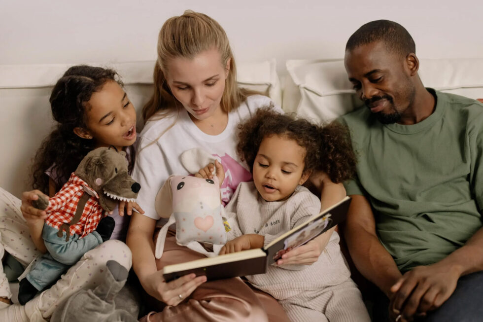 Family reading together with toys on couch