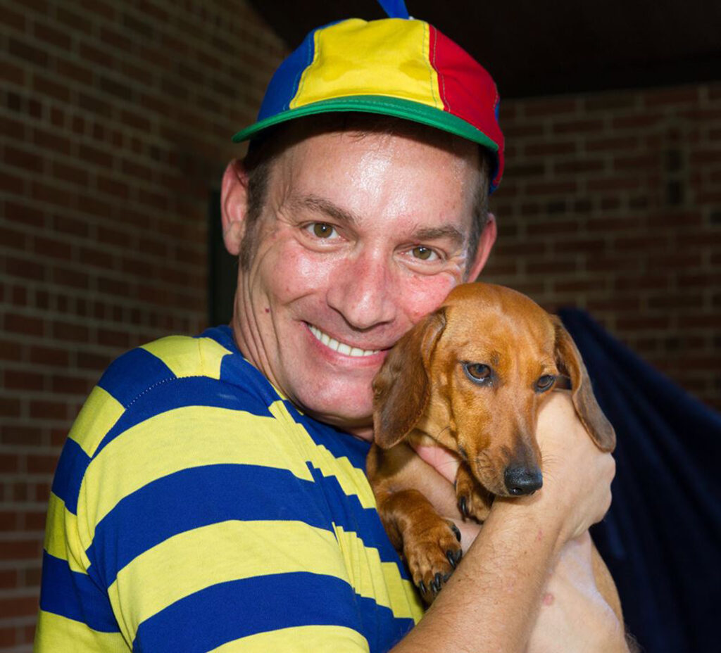 Man smiling with dachshund dog.