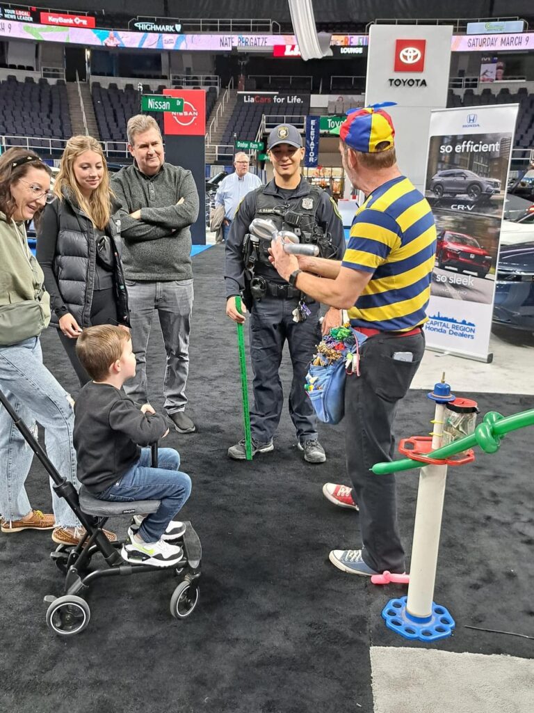 Family enjoys magic show at car exhibition event.